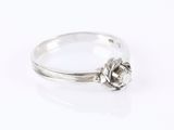 a white gold ring with a single diamond in the center