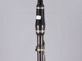 a close up of a black and gold clarinet on a clear surface