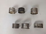 several different types of silver rings on a white surface