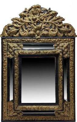 un miroir sculpté avec un cadre doré sur fond blanc