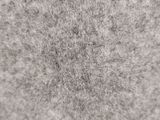 a close up of a white and gray carpet with a circular pattern