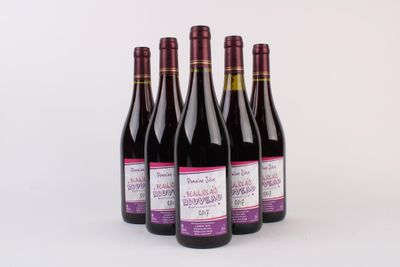 trois bouteilles de vin sont alignées sur une surface blanche