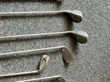 several golf clubs are lined up on a carpeted floor