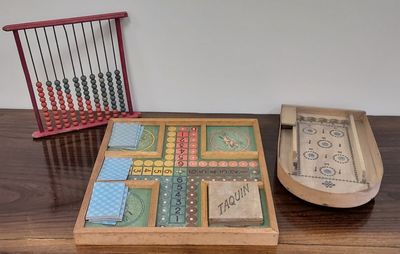 une boîte en bois contenant un abaque et un plateau en bois, posée sur une table