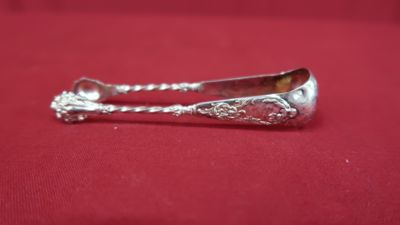 a silver spoon on a red cloth with a spoon in the middle