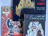 trois livres posés sur une table blanche, surmontés d'une couronne dorée