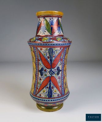 un vase coloré posé sur une table, sur fond blanc