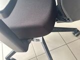 a black office chair with a black seat on the floor
