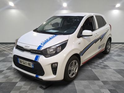La voiture blanche et bleue est garée sur un sol à damier.