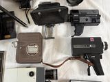 a lot of different types of cameras on a bed