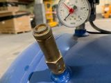 a pressure gauge on top of a blue tank