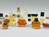 several bottles of perfume are lined up on a white surface