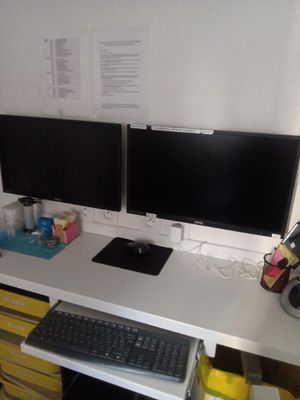 deux écrans d'ordinateur sur un bureau avec un clavier et une souris