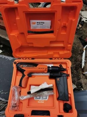 an orange case with tools in it sitting on top of a pile of junk