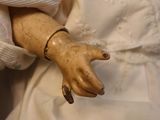 a doll that is wearing a white dress and a blue necklace