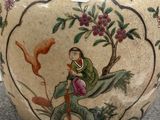 a vase with a painting on it sitting on a table