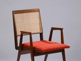 une image représentant une chaise avec un coussin rouge et une structure en bois