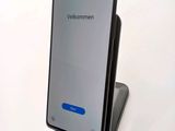 a close up of a cell phone on a stand on a white surface