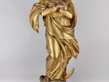 une statue en or représentant une femme tenant un oiseau au-dessus d'un globe terrestre