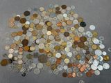 a pile of coins on the floor next to a bottle of water