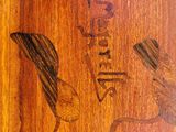 a wooden plaque with a bird on it that has writing on it