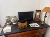 a dresser with a television and other items on it