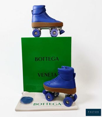 two blue roller skates sitting on top of a green box