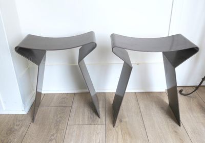deux tabourets placés l'un à côté de l'autre sur un plancher en bois