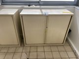 two cupboards in the corner of a room with a window
