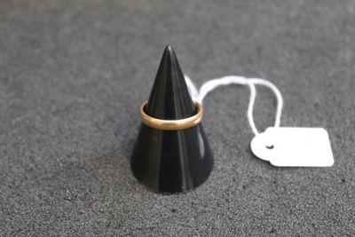 un cône noir orné d'un anneau doré, à côté d'une étiquette de prix
