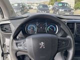 a steering wheel and dashboard of a car in a parking lot
