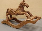 a wooden rocking horse that is sitting on the floor