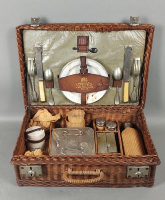 a wicker picnic basket with silverware and utensils in it
