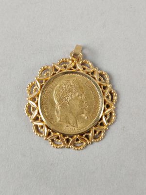 un pendentif en forme de pièce d'or sur lequel est gravé le visage d'une femme