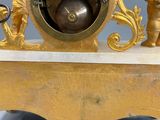 a gold clock with angels on it on a table