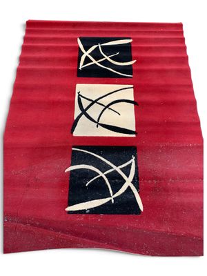 un tapis rouge orné de motifs noirs et blancs