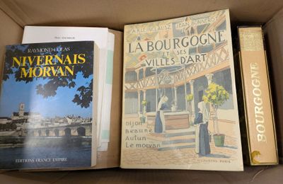three books in a cardboard box on a table next to each other