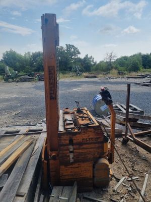 un homme qui se tient à côté d'un tas de bois