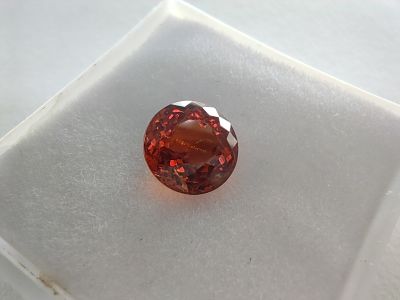 a close up of a red diamond sitting on top of a white surface
