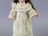 an image of a doll of a little girl in a white dress