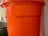 un grand seau orange posé sur une table bleue