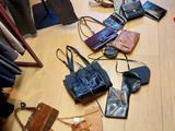 il y a beaucoup de sacs et de sacs à main par terre dans cette pièce
