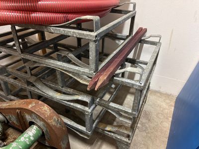a stack of metal racks with red hoses on top of them