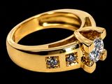 a close up of a gold ring with a diamond on it