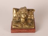 statue of a woman in a bed with a pillow on it