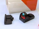 a red dot that is sitting next to a black object