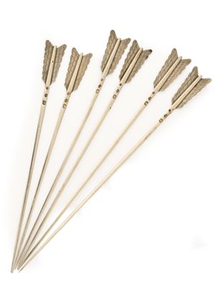 un ensemble de six flèches en laiton sur fond blanc