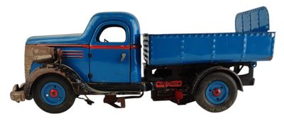 un camion jouet posé sur une surface blanche