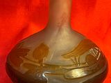un vase en verre orné d'un motif, posé sur un tissu rouge