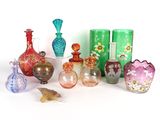 de nombreux vases en verre de différentes couleurs posés sur une surface blanche